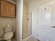 Bathroom showcasing a toilet, a glass-enclosed shower, and a storage cabinet at 8700 E University Dr # 953, Mesa, AZ 85207