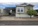 Charming home exterior featuring a covered carport, tidy landscaping, and attractive architectural details at 8700 E University Dr # 953, Mesa, AZ 85207