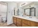 Bathroom featuring a double sink vanity, vanity lighting, and a decorative mirror with a view into another bathroom at 914 N Cherry --, Mesa, AZ 85201
