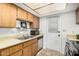 Functional kitchen featuring wooden cabinets, a stainless steel sink, and a door to the outside at 914 N Cherry --, Mesa, AZ 85201