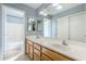 Bathroom featuring a double sink vanity, a large mirror, a combination bathtub and shower, and blue walls at 10318 W Luke Ave, Glendale, AZ 85307