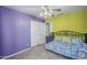 Bedroom with one purple and one green wall, with tile floors, a day bed, and ceiling fan at 10318 W Luke Ave, Glendale, AZ 85307