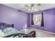 Bedroom with a purple wall, a small window, a ceiling fan, and a bed frame with a metal headboard at 10318 W Luke Ave, Glendale, AZ 85307