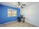 Bedroom with blue and white walls featuring a desk, chair, computer and a view to the backyard at 10318 W Luke Ave, Glendale, AZ 85307