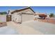 Attached garage with desert landscaping and tiled roof at 10318 W Luke Ave, Glendale, AZ 85307