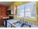 Bright kitchen with stainless steel sink, appliances, and a window view of the backyard at 10318 W Luke Ave, Glendale, AZ 85307