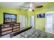 Spacious main bedroom with green walls, decorative wood dresser, ceiling fan and view to ensuite bathroom at 10318 W Luke Ave, Glendale, AZ 85307