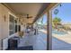 Large covered patio with ceiling fan and outdoor decor overlooks the sparkling swimming pool at 10318 W Luke Ave, Glendale, AZ 85307