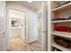 Hallway view to the bathroom featuring tiled floors, neutral-colored walls, and built-in shelving perfect for storage at 14950 W Mountain View Blvd # 5312, Surprise, AZ 85374