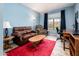 Cozy living room features plush seating, a bright red rug, a light blue accent wall, and natural light at 14950 W Mountain View Blvd # 5312, Surprise, AZ 85374