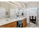 Bright bathroom with double sinks, spacious countertops and a glass-enclosed shower at 15546 W Whitton Ave, Goodyear, AZ 85395