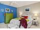 Bedroom featuring a blue accent wall, white trim, and neutral carpeting at 15546 W Whitton Ave, Goodyear, AZ 85395