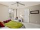 Comfortable bedroom featuring a ceiling fan, large window, and neutral carpeting at 15546 W Whitton Ave, Goodyear, AZ 85395