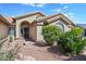 Charming front entrance featuring a tiled roof, stucco siding, and desert landscaping at 15546 W Whitton Ave, Goodyear, AZ 85395