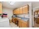 Well-equipped laundry room featuring wood cabinets, tile flooring, and a utility sink at 15546 W Whitton Ave, Goodyear, AZ 85395