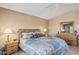 Bright main bedroom with natural wood furniture, soft lighting, and comfortable decor at 15546 W Whitton Ave, Goodyear, AZ 85395