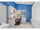 Bright office featuring a blue accent wall, white built-in desk and shelving, and shutters at 15546 W Whitton Ave, Goodyear, AZ 85395