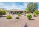 This backyard features desert landscaping, a covered patio, and desert views at 16406 W Peppertree Ct, Surprise, AZ 85387