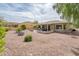 This backyard is landscaped with desert plants and offers a covered patio at 16406 W Peppertree Ct, Surprise, AZ 85387