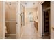 Hallway to bathroom featuring closet with shelves and shoe storage, and the bathroom with a single sink and shower at 16406 W Peppertree Ct, Surprise, AZ 85387