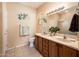 Bathroom featuring double sinks, decorative wall art, and a large mirror with overhead lighting at 16406 W Peppertree Ct, Surprise, AZ 85387