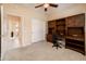 This bedroom features a built-in desk, neutral carpeting, and a closet at 16406 W Peppertree Ct, Surprise, AZ 85387