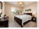 Bedroom featuring queen bed, wood dresser with a view to the street out the window at 16406 W Peppertree Ct, Surprise, AZ 85387