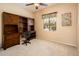 This bedroom features a built-in desk, neutral carpeting, and a ceiling fan at 16406 W Peppertree Ct, Surprise, AZ 85387