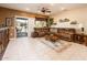 Bright living room with tile floor, a ceiling fan, and sliding door access to the patio at 16406 W Peppertree Ct, Surprise, AZ 85387