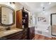 Well-lit bathroom featuring dual vanities, granite countertops, a soaking tub, and dark wood cabinetry at 2328 N 123Rd Ln, Avondale, AZ 85392