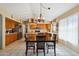 Cozy dining area featuring a wooden table, pendant lighting, and cabinetry at 2328 N 123Rd Ln, Avondale, AZ 85392