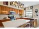 Bright eat-in kitchen featuring wooden cabinets, modern appliances and pendant lighting at 2328 N 123Rd Ln, Avondale, AZ 85392