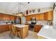 Bright eat-in kitchen featuring wooden cabinets, modern appliances and a center island at 2328 N 123Rd Ln, Avondale, AZ 85392