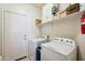 A laundry room featuring a washer, dryer, storage shelves, and utility sink at 2328 N 123Rd Ln, Avondale, AZ 85392