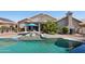 Inviting swimming pool with lounge chairs, patio area, and lush tropical landscaping at 2328 N 123Rd Ln, Avondale, AZ 85392