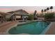 Beautiful backyard pool reflecting the home's architecture and a colorful sunset, ideal for relaxation at 2328 N 123Rd Ln, Avondale, AZ 85392