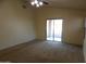 Open bedroom with sliding glass doors leading to the outside and neutral-colored carpet at 25176 W Cranston Ln, Buckeye, AZ 85326