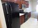 Modern kitchen with stainless steel appliances and dark wood cabinets at 25176 W Cranston Ln, Buckeye, AZ 85326