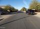 Asphalt street view featuring sidewalks, nearby homes, and neighborhood trees at 25176 W Cranston Ln, Buckeye, AZ 85326