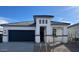 Contemporary home featuring a gray roof, neutral stucco, decorative stone accents, and a two-car garage at 25442 W Graham Trl, Buckeye, AZ 85326