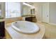 Bright bathroom featuring a tile floor, large tub, and stylish vanity at 2830 E Fruitvale Ave, Gilbert, AZ 85297