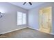 Neutral bedroom featuring plush carpet, a ceiling fan and a window bringing in natural light at 2830 E Fruitvale Ave, Gilbert, AZ 85297