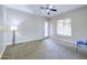 Bright, carpeted bedroom featuring a ceiling fan and ample natural light from a large window at 2830 E Fruitvale Ave, Gilbert, AZ 85297