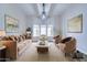 Bright living room with a comfortable tan sofa, accent chairs, and a large bay window with natural light at 2830 E Fruitvale Ave, Gilbert, AZ 85297