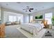 Serene main bedroom with a king-size bed, soft lighting, a ceiling fan, and an adjacent sitting area at 2830 E Fruitvale Ave, Gilbert, AZ 85297