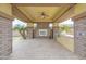 Covered outdoor kitchen with stone fireplace, ceiling fan, built-in BBQ, and paver flooring at 2830 E Fruitvale Ave, Gilbert, AZ 85297