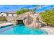 Backyard pool featuring a rock waterfall slide, landscaping, and clear blue water at 2830 E Fruitvale Ave, Gilbert, AZ 85297