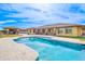 In-ground pool with bright blue water, stone patio, and views of the back of the home at 2830 E Fruitvale Ave, Gilbert, AZ 85297