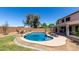 Stunning backyard featuring a lagoon-style pool, lush greenery, and ample space for relaxation and outdoor gatherings at 34990 N Spur Cir, San Tan Valley, AZ 85144