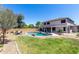 Lush backyard with a private pool, patio area, and mature trees, perfect for outdoor enjoyment and relaxation at 34990 N Spur Cir, San Tan Valley, AZ 85144